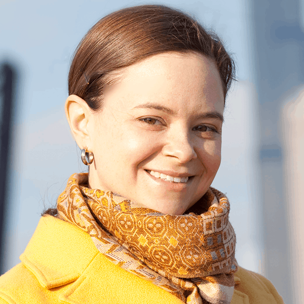 This is a headshot of Carie Bires, wearing a yellow coat and scarf.