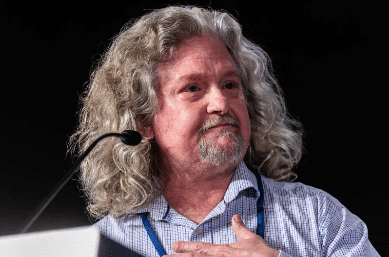 Schoolkids raising their hands in classroom